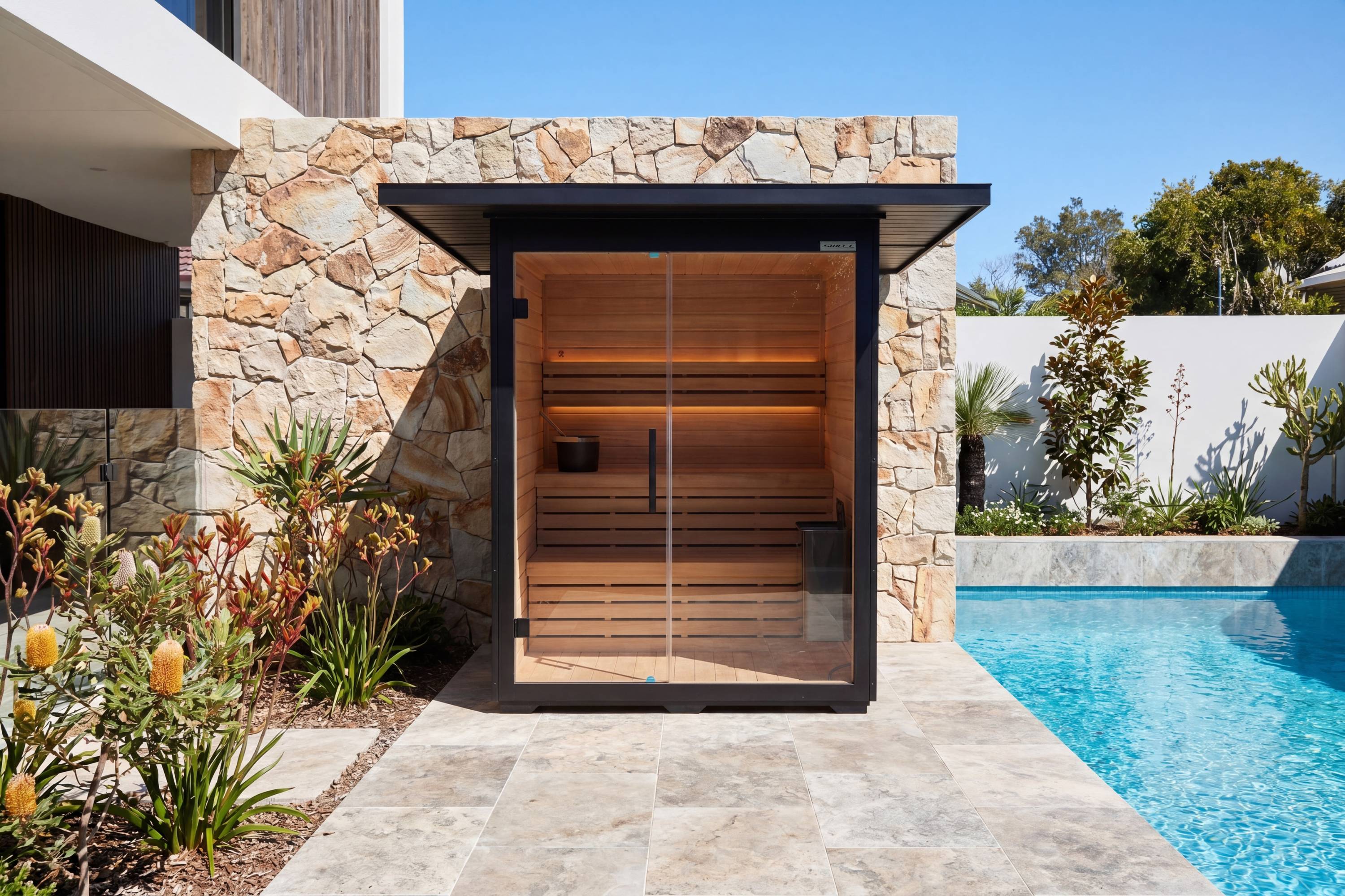 Front view of Swell Black Eco 4 outdoor traditional sauna beside backyard pool