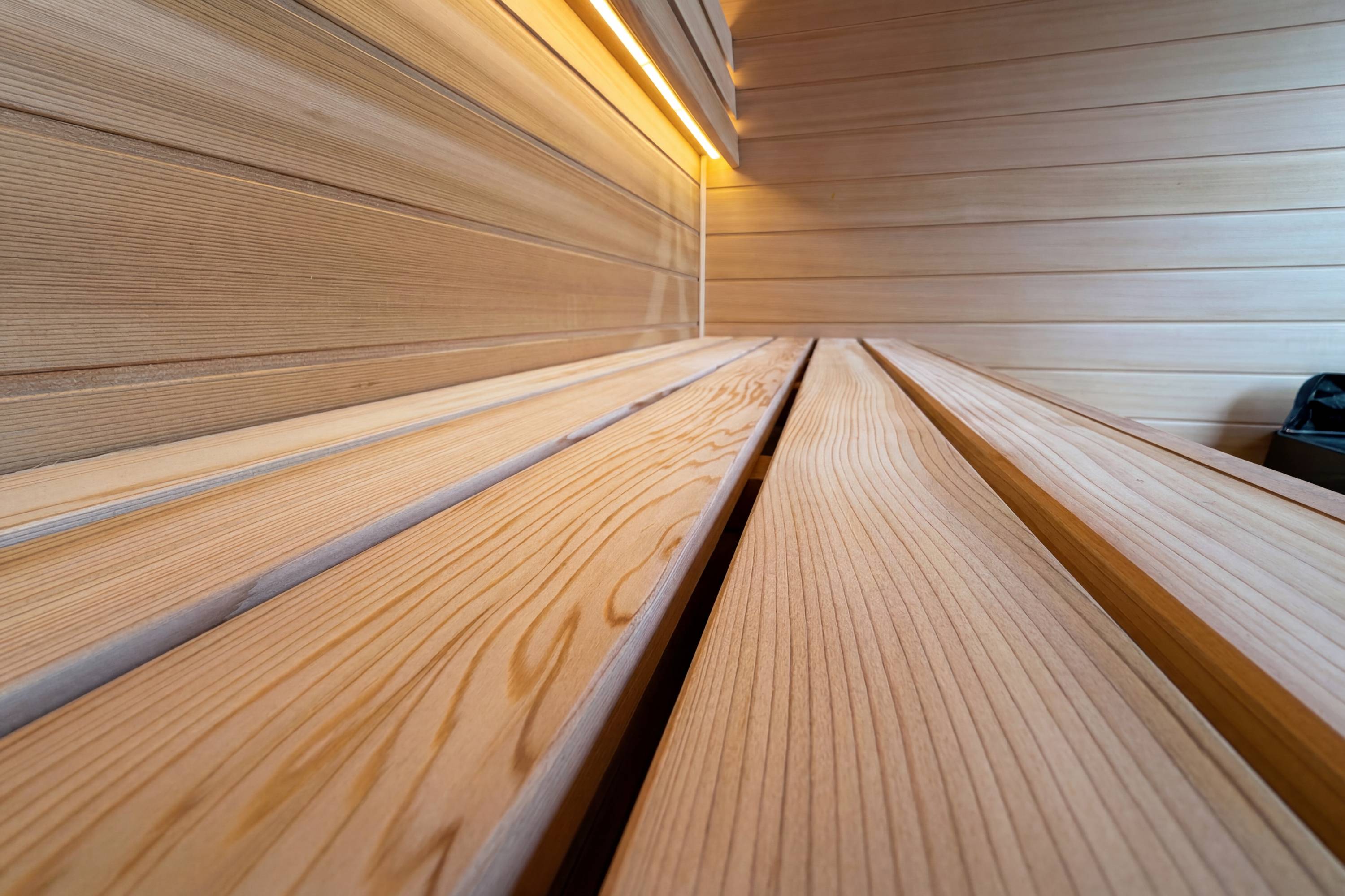 Cedar sauna bench slats with warm interior lighting in Swell Black Eco 4 sauna