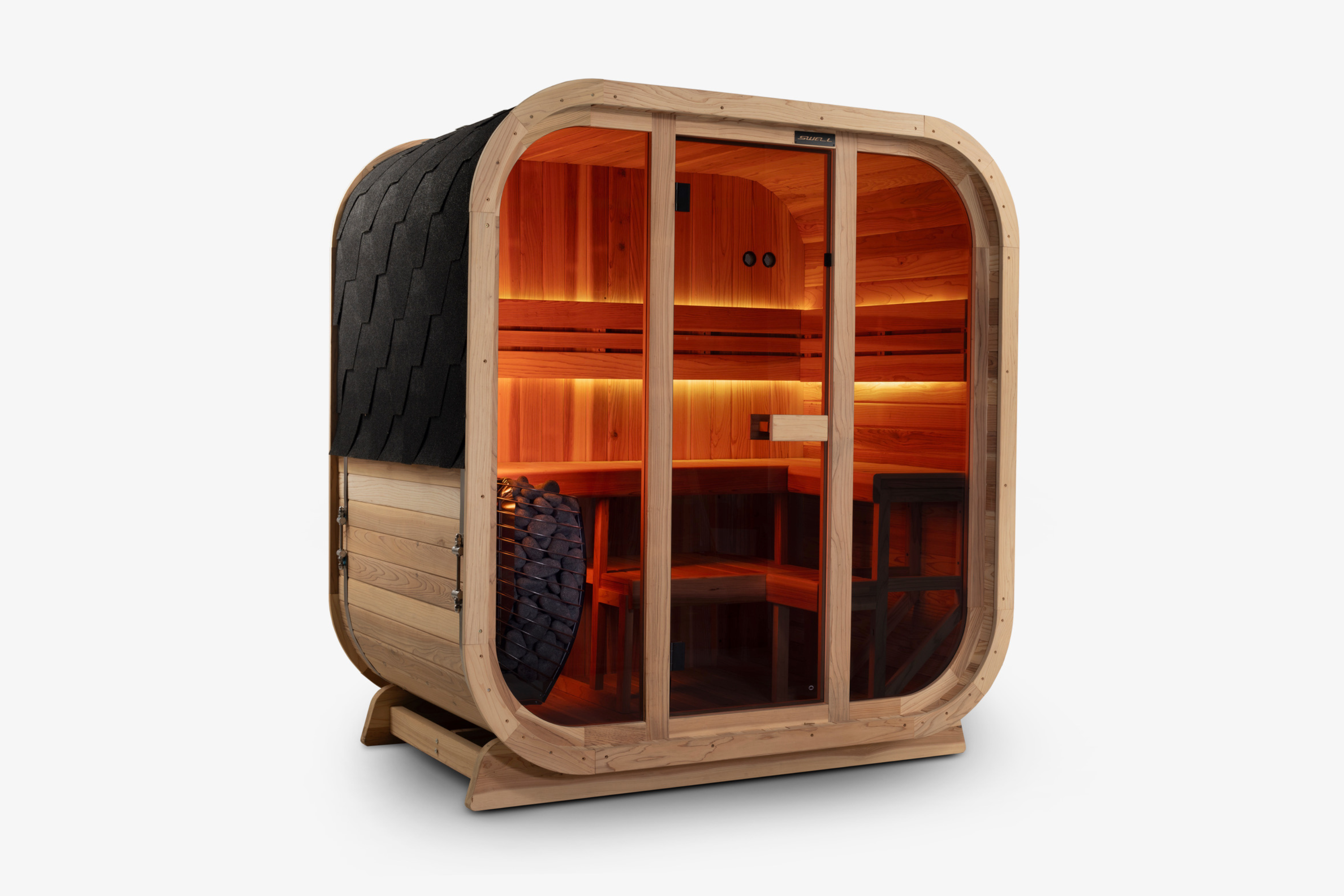 Swell Cedar Cube 4 sauna with warm amber lighting, glass front and black shingle roof