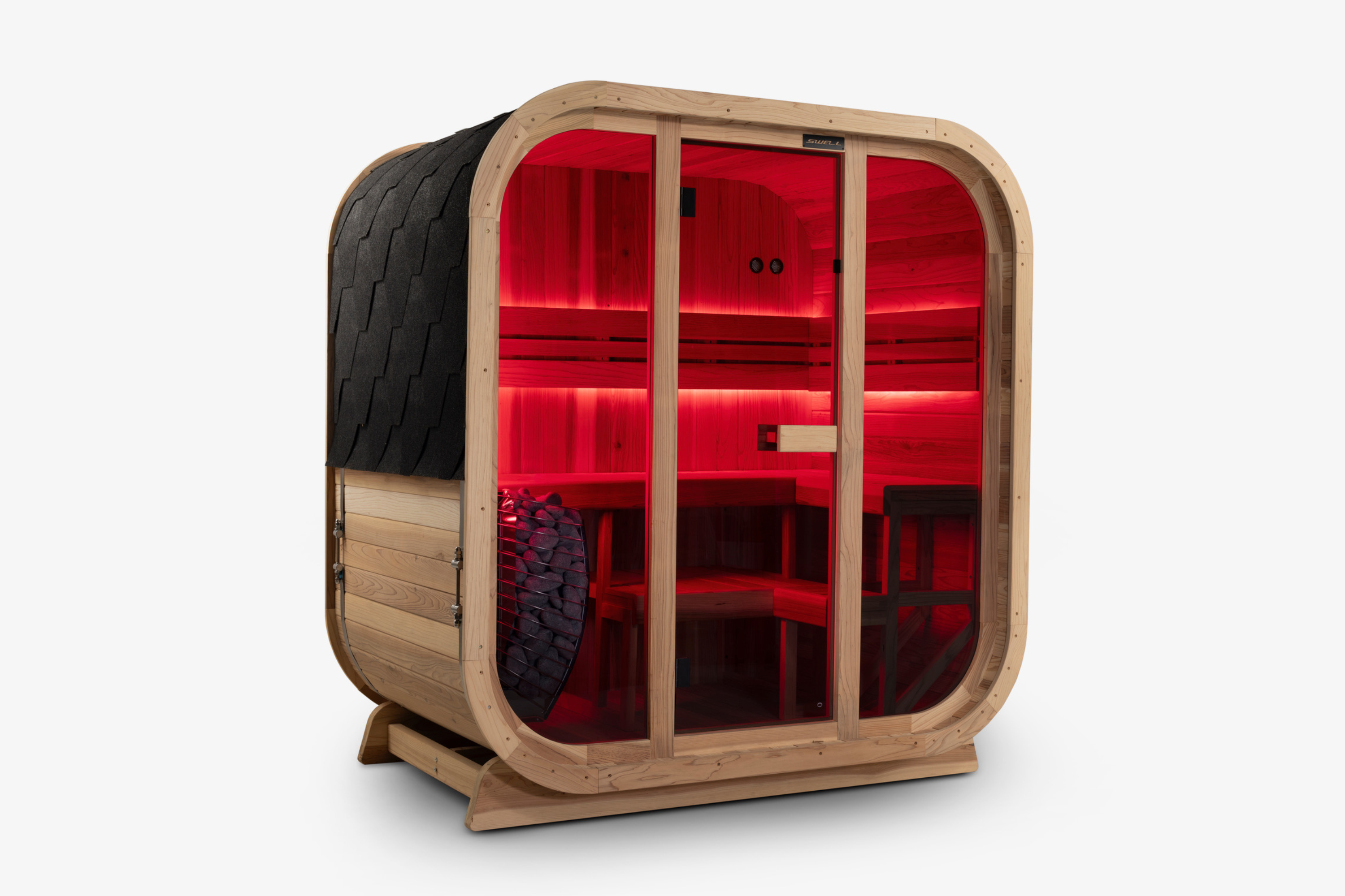 Angled view of a Swell Cedar Cube 4 sauna with red lighting and a stone-filled heater