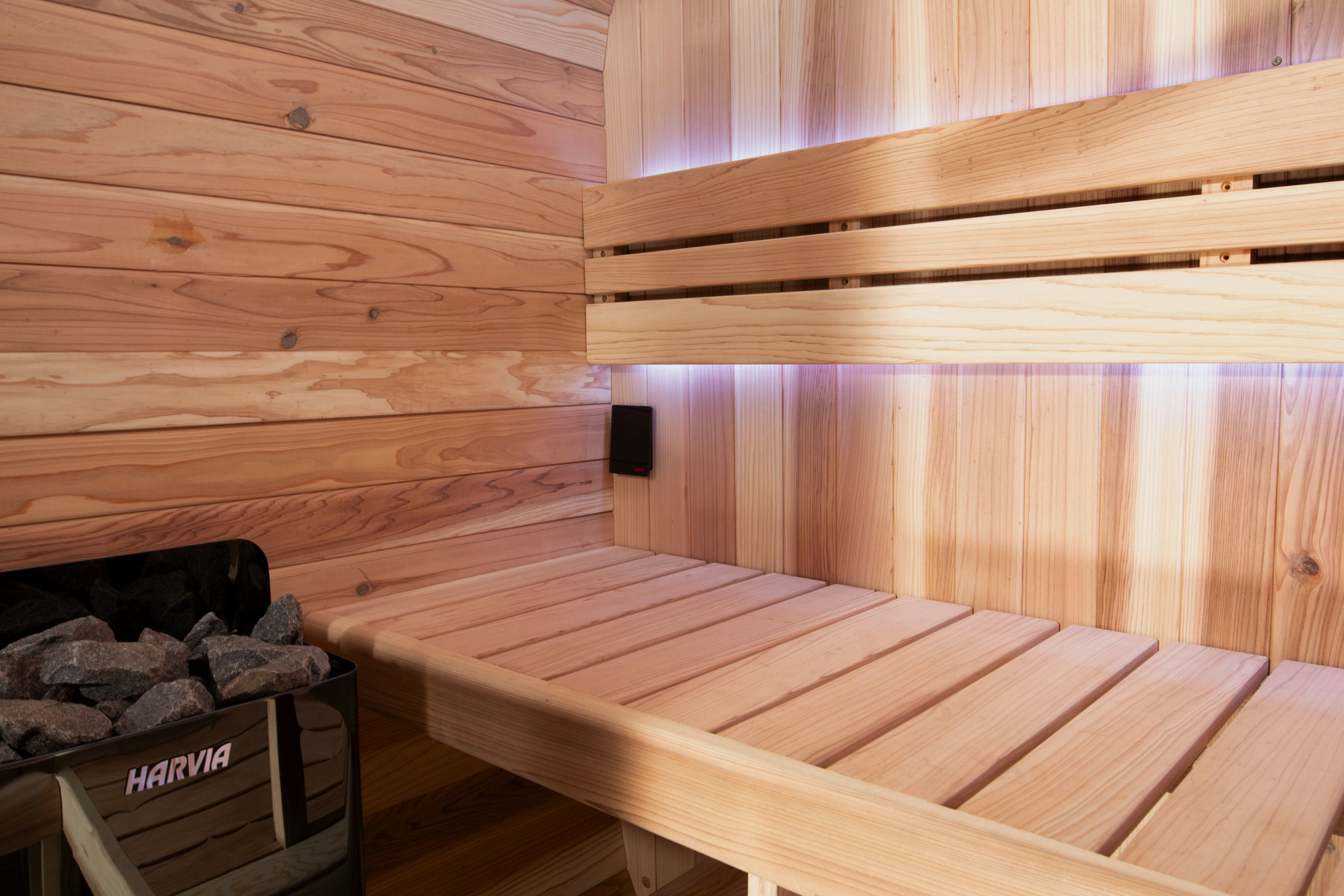 Swell Cedar Cube range interior with timber benches, purple lighting and a Harvia heater
