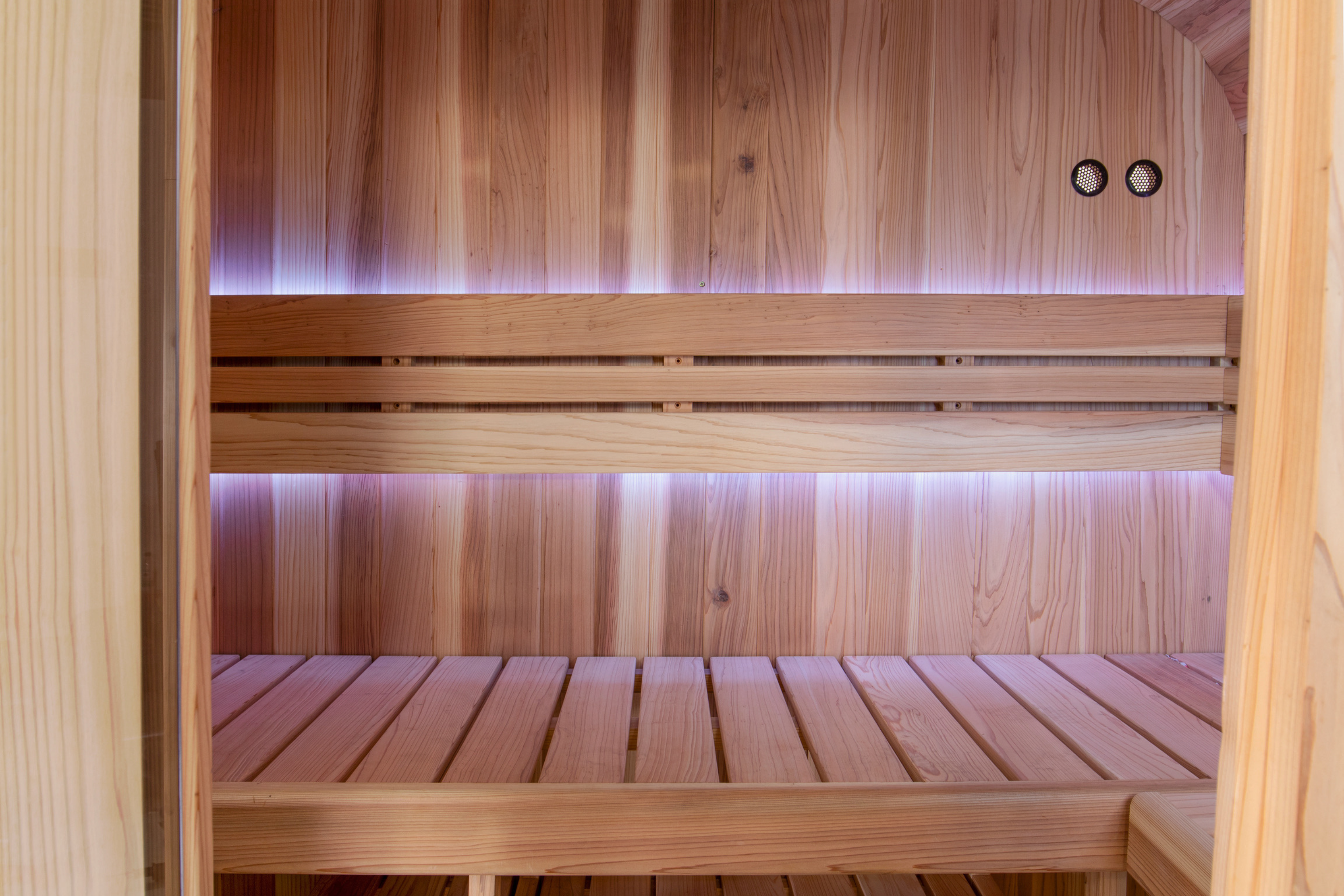 View through the doorway of Swell Cedar Cube 4 timber benches, wall gauges and purple lighting
