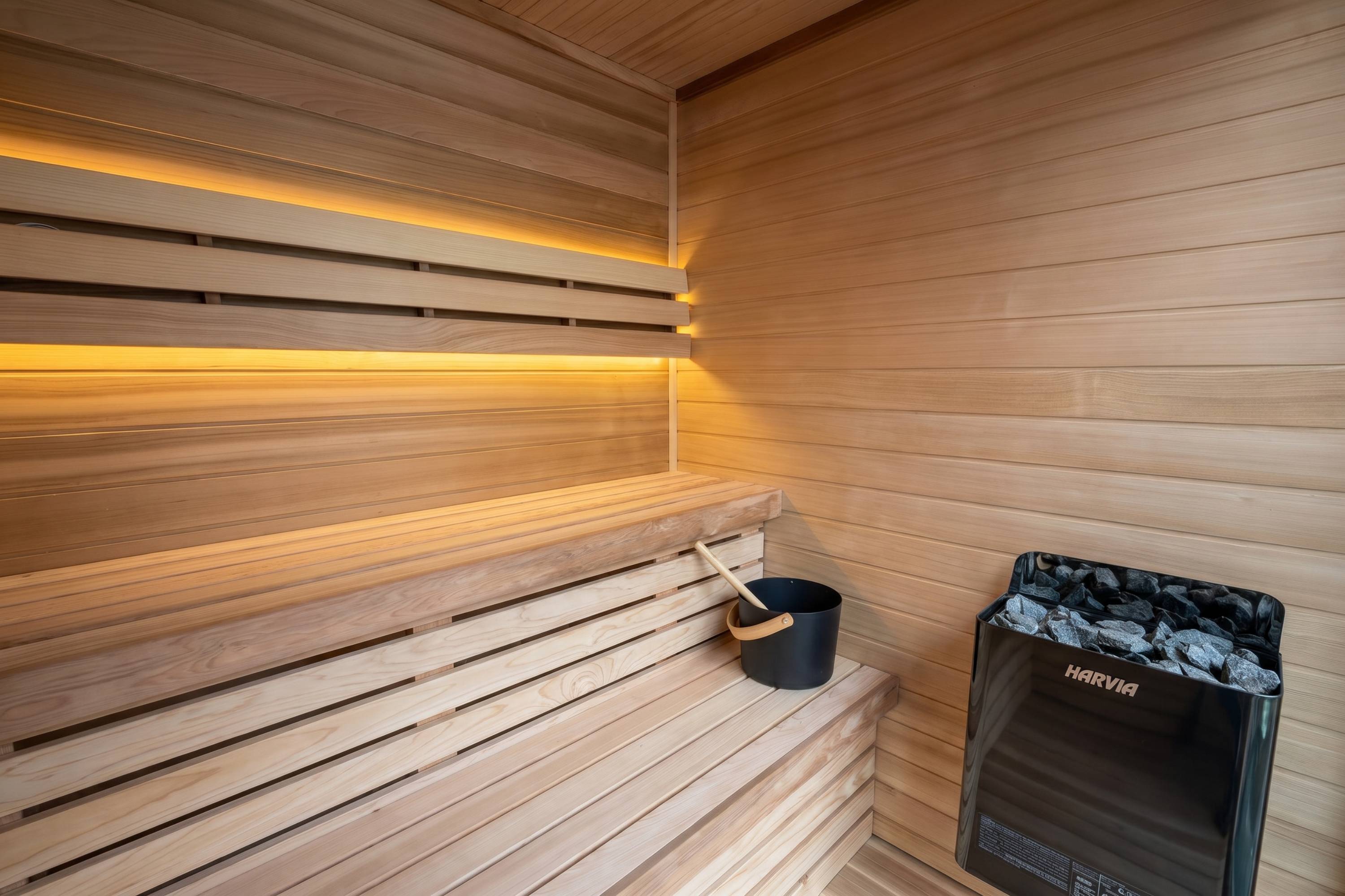 Cedar sauna benches with sauna bucket and Harvia heater inside Swell Black Eco 4